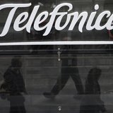 People are reflected as they walk past Spanish telecom group Telefonica's flagship store in central Madrid November 8, 2013. REUTERS/Sergio People are reflected as they walk past Spanish telecom group Telefonica's flagship store in central Madrid November 8, 2013. REUTERS/Sergio