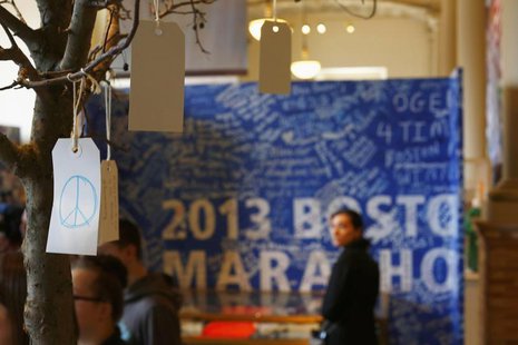 A peace sign is seen on a message tree as visitors look at artefacts in a public exhibition of objects and mementos left at the makeshift me A peace sign is seen on a message tree as visitors look at artefacts in a public exhibition of objects and mementos left at the makeshift me