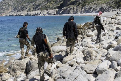 Rebel fighters walk with their weapons at the beach in Latakia province near the town of Kasab April 5, 2014. Picture taken April 5, 2014. R Rebel fighters walk with their weapons at the beach in Latakia province near the town of Kasab April 5, 2014. Picture taken April 5, 2014. R