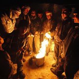 Syrian refugees from the town of Qara gather around a fire to keep themselves warm in a Syrian refugee camp on the Lebanese border town of A Syrian refugees from the town of Qara gather around a fire to keep themselves warm in a Syrian refugee camp on the Lebanese border town of A