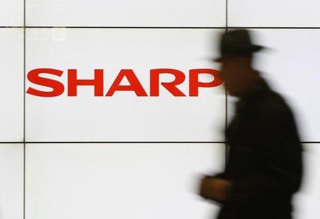 A pedestrian walks past a logo of Sharp Corp at a train station in Tokyo February 3, 2014. REUTERS/Yuya Shino A pedestrian walks past a logo of Sharp Corp at a train station in Tokyo February 3, 2014. REUTERS/Yuya Shino