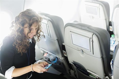 A woman uses her mobile phone to test a new high speed inflight Internet service named Fli-Fi while on a special JetBlue media flight out of A woman uses her mobile phone to test a new high speed inflight Internet service named Fli-Fi while on a special JetBlue media flight out of