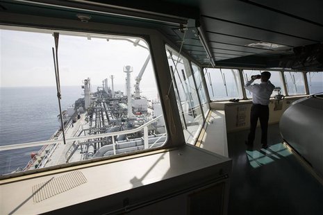An officer uses binoculars as he stands on a tanker carrying liquefied natural gas in the Mediterranean, some 10 km (6 miles) from the coast An officer uses binoculars as he stands on a tanker carrying liquefied natural gas in the Mediterranean, some 10 km (6 miles) from the coast