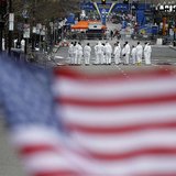Law enforcement evidence technicians are seen behind a U.S. flag placed at a memorial for the victims as they continue to search the scene o Law enforcement evidence technicians are seen behind a U.S. flag placed at a memorial for the victims as they continue to search the scene o