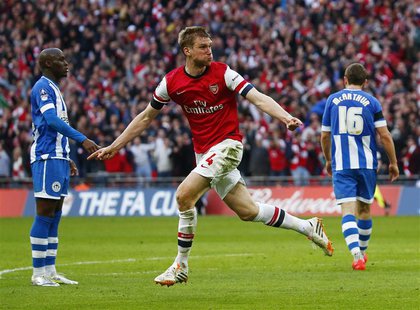 Arsenal's Per Mertesacker celebrates his goal against Wigan Athletic during their English FA Cup semi-final soccer match at Wembley Stadium Arsenal's Per Mertesacker celebrates his goal against Wigan Athletic during their English FA Cup semi-final soccer match at Wembley Stadium
