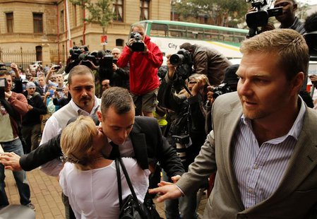 Olympic and Paralympic track star Oscar Pistorius is hugged by a supporter as he arrives ahead of his trial at the North Gauteng High Court Olympic and Paralympic track star Oscar Pistorius is hugged by a supporter as he arrives ahead of his trial at the North Gauteng High Court
