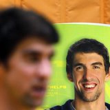 U.S. swimmer Michael Phelps stands next to a banner with his image during a promotional event in Sao Paulo December 4, 2013. REUTERS/Paulo W U.S. swimmer Michael Phelps stands next to a banner with his image during a promotional event in Sao Paulo December 4, 2013. REUTERS/Paulo W