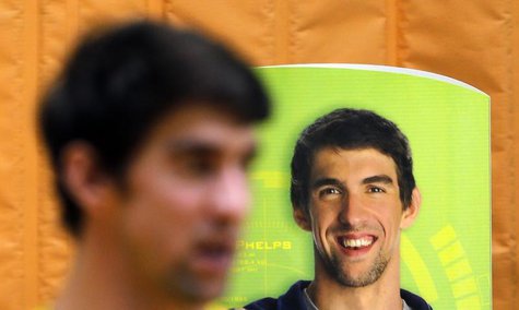 U.S. swimmer Michael Phelps stands next to a banner with his image during a promotional event in Sao Paulo December 4, 2013. REUTERS/Paulo W U.S. swimmer Michael Phelps stands next to a banner with his image during a promotional event in Sao Paulo December 4, 2013. REUTERS/Paulo W