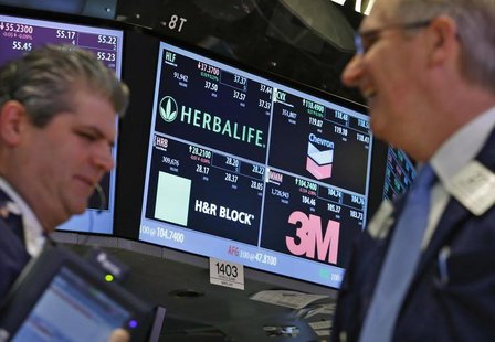 A screen displays the tickers symbols for; Herbalife, Chevron, H&R Block and 3M as traders work on the floor at the New York Stock Exchange, A screen displays the tickers symbols for; Herbalife, Chevron, H&R Block and 3M as traders work on the floor at the New York Stock Exchange,