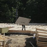 A lone carpenter carries plywood flooring at a building site of Mid-Atlantic Builders' 'The Villages of Savannah' in Brandywine, Maryland Ma A lone carpenter carries plywood flooring at a building site of Mid-Atlantic Builders' 'The Villages of Savannah' in Brandywine, Maryland Ma