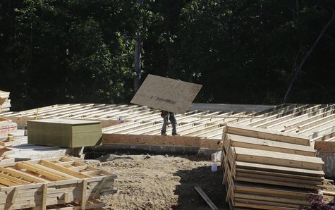 A lone carpenter carries plywood flooring at a building site of Mid-Atlantic Builders' 'The Villages of Savannah' in Brandywine, Maryland Ma A lone carpenter carries plywood flooring at a building site of Mid-Atlantic Builders' 'The Villages of Savannah' in Brandywine, Maryland Ma