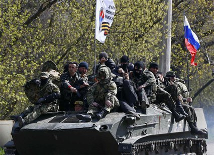 Armed men, wearing black and orange ribbons of St. George - a symbol widely associated with pro-Russian protests in Ukraine, drive an armour Armed men, wearing black and orange ribbons of St. George - a symbol widely associated with pro-Russian protests in Ukraine, drive an armour