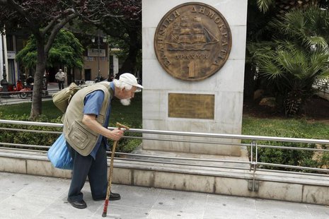 A man makes his way past a replica of a one drachma coin outside the Athens Town Hall May 21, 2012. REUTERS/Yorgos Karahalis A man makes his way past a replica of a one drachma coin outside the Athens Town Hall May 21, 2012. REUTERS/Yorgos Karahalis