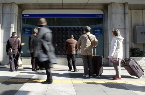 Pedestrians look at an electronic board showing stock prices outside a brokerage in Tokyo February 18, 2014. REUTERS/Yuya Shino Pedestrians look at an electronic board showing stock prices outside a brokerage in Tokyo February 18, 2014. REUTERS/Yuya Shino
