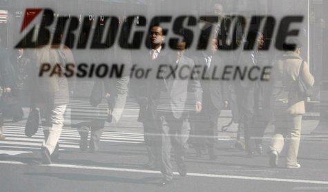 Pedestrians are reflected in a signboard of Bridgestone Corp. at its headquarters in Tokyo February 19, 2009. REUTERS/Kim Kyung-Hoon Pedestrians are reflected in a signboard of Bridgestone Corp. at its headquarters in Tokyo February 19, 2009. REUTERS/Kim Kyung-Hoon