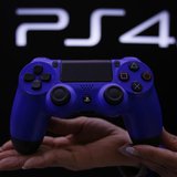 A staff at the PlayStation 4 launch event poses with the PlayStation 4's game controller before its domestic launch event at the Sony Showro A staff at the PlayStation 4 launch event poses with the PlayStation 4's game controller before its domestic launch event at the Sony Showro
