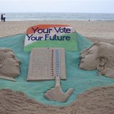 A visitor walks next to a sand sculpture on elections made by Indian sand artist Sudarshan Pattnaik at a beach at Puri in the eastern Indian A visitor walks next to a sand sculpture on elections made by Indian sand artist Sudarshan Pattnaik at a beach at Puri in the eastern Indian