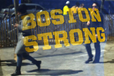 Pedestrians are reflected in a "Boston Strong" t-shirt displayed in a shop window, as they walk past the site of the first bomb blast from t Pedestrians are reflected in a "Boston Strong" t-shirt displayed in a shop window, as they walk past the site of the first bomb blast from t