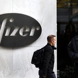 A man walks past the Pfizer logo next to a New York Police Officer standing outside Pfizer's world headquarters in New York November 5, 2013 A man walks past the Pfizer logo next to a New York Police Officer standing outside Pfizer's world headquarters in New York November 5, 2013