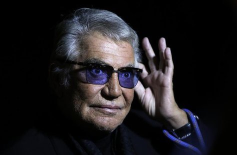 Italian designer Roberto Cavalli acknowledges the audience at the end of his Spring/Summer 2014 collection during Milan Fashion Week Septemb Italian designer Roberto Cavalli acknowledges the audience at the end of his Spring/Summer 2014 collection during Milan Fashion Week Septemb
