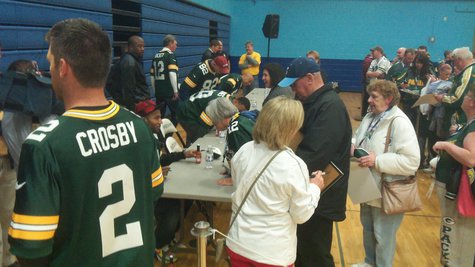 Packer CB Jarrett Bush signing autographs while Mason Crosby talks with the media Packer CB Jarrett Bush signing autographs while Mason Crosby talks with the media