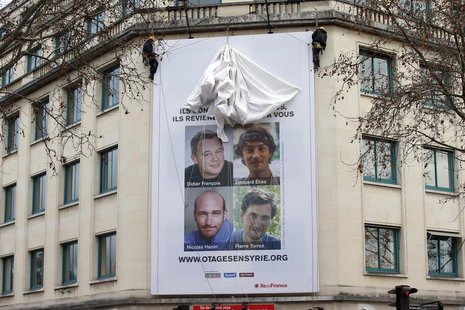 A poster calling for the release of French journalists Didier Francois, Edouard Elias, Nicolas Henin and Pierre Torres is installed on the f A poster calling for the release of French journalists Didier Francois, Edouard Elias, Nicolas Henin and Pierre Torres is installed on the f