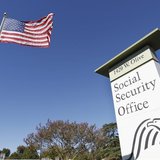 An American flag flutters in the wind next to signage for a United States Social Security Administration office in Burbank, California Octob An American flag flutters in the wind next to signage for a United States Social Security Administration office in Burbank, California Octob