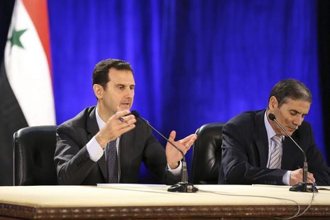 Syria's President Bashar al-Assad (L) meets with professors and students of political science college in Damascus April 13,2014, in this han Syria's President Bashar al-Assad (L) meets with professors and students of political science college in Damascus April 13,2014, in this han