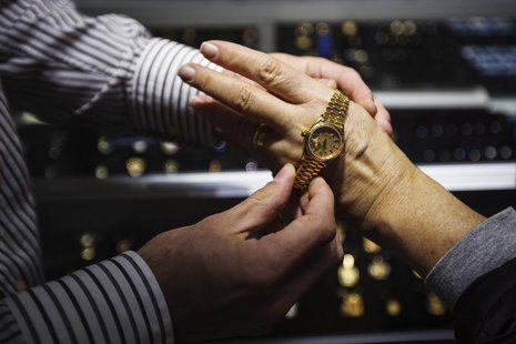 Store manager Jared Minsky talks to a potential customer about gold watches inside the Gold Standard jewellery store in New York, April 15, Store manager Jared Minsky talks to a potential customer about gold watches inside the Gold Standard jewellery store in New York, April 15,