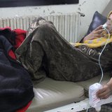 A woman, affected by what activists say was a gas attack, breathes through an oxygen mask inside a field hospital in Kfar Zeita village in t A woman, affected by what activists say was a gas attack, breathes through an oxygen mask inside a field hospital in Kfar Zeita village in t