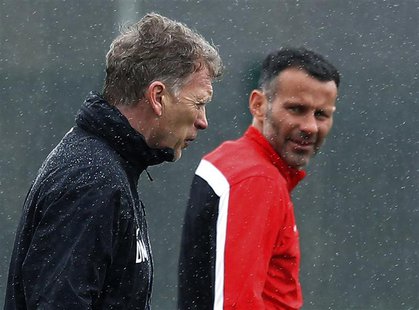 Manchester United's manager David Moyes (L) walks past Ryan Giggs during a training session at the club's Carrington training complex in Man Manchester United's manager David Moyes (L) walks past Ryan Giggs during a training session at the club's Carrington training complex in Man