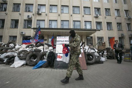 A pro-Russian armed man walks near a barricade outside a regional government building seized by them in Kramatorsk, eastern Ukraine April 22 A pro-Russian armed man walks near a barricade outside a regional government building seized by them in Kramatorsk, eastern Ukraine April 22