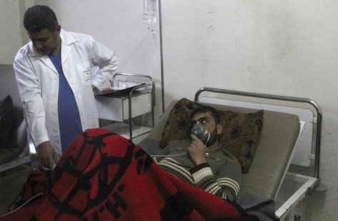 A man, affected by what activists say was a gas attack, breathes through an oxygen mask inside a field hospital in Kfar Zeita village in the A man, affected by what activists say was a gas attack, breathes through an oxygen mask inside a field hospital in Kfar Zeita village in the