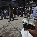 A money changer holds a stack of U.S. dollars at Kabul's largest money market April 23, 2014. REUTERS/Omar Sobhani A money changer holds a stack of U.S. dollars at Kabul's largest money market April 23, 2014. REUTERS/Omar Sobhani