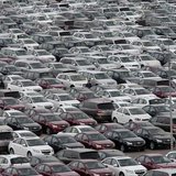 An employee yawns as he walks among General Motors' new Chinese-made cars at a parking lot in Shenyang, Liaoning province April 21, 2014. RE An employee yawns as he walks among General Motors' new Chinese-made cars at a parking lot in Shenyang, Liaoning province April 21, 2014. RE