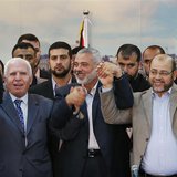 Senior Fatah official Azzam Al-Ahmed (L), head of the Hamas government Ismail Haniyeh (C) and senior Hamas leader Moussa Abu Marzouq hold th Senior Fatah official Azzam Al-Ahmed (L), head of the Hamas government Ismail Haniyeh (C) and senior Hamas leader Moussa Abu Marzouq hold th