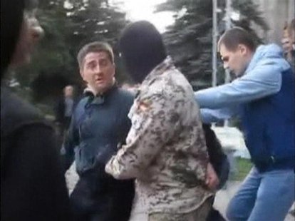 Horlivka city deputy Volodymyr Rybak (L) is manhandled by several men, among them a masked man in camouflage, outside a city hall building i Horlivka city deputy Volodymyr Rybak (L) is manhandled by several men, among them a masked man in camouflage, outside a city hall building i