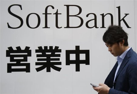 A man holding his mobile phone walks past the logo of Softbank Corp at its branch in Tokyo April 22, 2014. REUTERS/Yuya Shino A man holding his mobile phone walks past the logo of Softbank Corp at its branch in Tokyo April 22, 2014. REUTERS/Yuya Shino