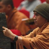 A Buddhist monk films, with an iPad, the closing ceremony of the seventh congress of Vietnam's Buddhist Sangha Association in Hanoi November A Buddhist monk films, with an iPad, the closing ceremony of the seventh congress of Vietnam's Buddhist Sangha Association in Hanoi November
