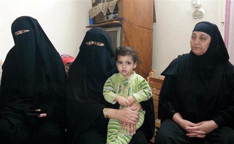 The wife (L) and other family members of Fahmy Abdel Raouf, who was killed with his 13-year-old son in a gun battle with security forces, si The wife (L) and other family members of Fahmy Abdel Raouf, who was killed with his 13-year-old son in a gun battle with security forces, si