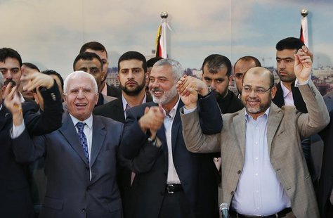Senior Fatah official Azzam Al-Ahmed (L), head of the Hamas government Ismail Haniyeh (C) and senior Hamas leader Moussa Abu Marzouq hold th Senior Fatah official Azzam Al-Ahmed (L), head of the Hamas government Ismail Haniyeh (C) and senior Hamas leader Moussa Abu Marzouq hold th