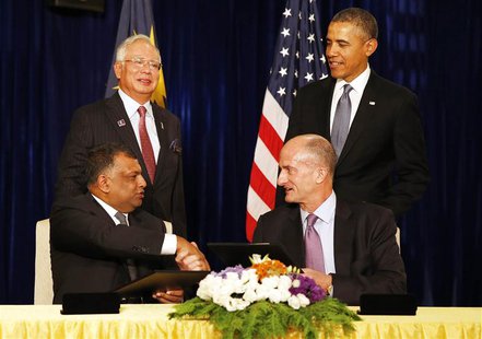 U.S. President Barack Obama (standing R) and Malaysian Prime Minister Najib Razak (standing L) witness the signing of a major business agree U.S. President Barack Obama (standing R) and Malaysian Prime Minister Najib Razak (standing L) witness the signing of a major business agree