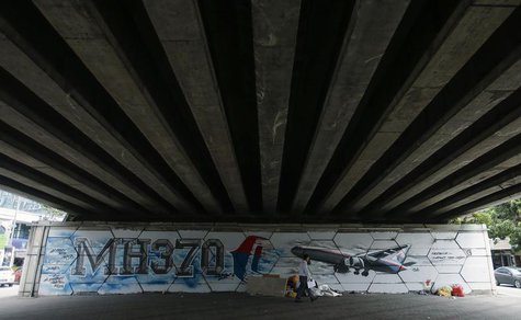 A man walks past graffiti of the missing Malaysia Airlines Flight MH370 in Kuala Lumpur April 15, 2014. REUTERS/Samsul Said A man walks past graffiti of the missing Malaysia Airlines Flight MH370 in Kuala Lumpur April 15, 2014. REUTERS/Samsul Said