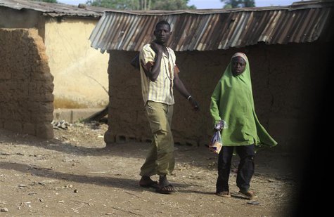 A man and a girl walk on a street in Bakin Kogi, Zango kataf, Kaduna State, March 22, 2014. Picture taken March 22, 2014. REUTERS/Afolabi So A man and a girl walk on a street in Bakin Kogi, Zango kataf, Kaduna State, March 22, 2014. Picture taken March 22, 2014. REUTERS/Afolabi So