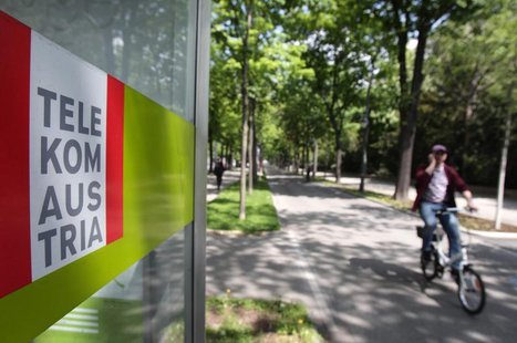A cyclist talks on his mobile phone as he passes a Telekom Austria phone booth in Vienna April 23, 2014. REUTERS/Heinz-Peter Bader A cyclist talks on his mobile phone as he passes a Telekom Austria phone booth in Vienna April 23, 2014. REUTERS/Heinz-Peter Bader