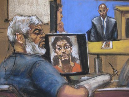 Abu Hamza al-Masri, the radical Islamist cleric facing U.S. terrorism charges, sits while a picture of shoe bomber Richard Reid is seen on a Abu Hamza al-Masri, the radical Islamist cleric facing U.S. terrorism charges, sits while a picture of shoe bomber Richard Reid is seen on a