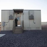 A border patrol agent opens the entrance to a temporary holding facility at the U.S. Department of Homeland Security's Forward Operating Bas A border patrol agent opens the entrance to a temporary holding facility at the U.S. Department of Homeland Security's Forward Operating Bas