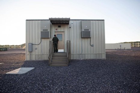 A border patrol agent opens the entrance to a temporary holding facility at the U.S. Department of Homeland Security's Forward Operating Bas A border patrol agent opens the entrance to a temporary holding facility at the U.S. Department of Homeland Security's Forward Operating Bas