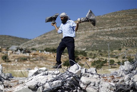 A Palestinian man holds damaged loudspeakers belonging to a mosque after it was demolished by Israeli bulldozers in Khirbet Al-Taweel villag A Palestinian man holds damaged loudspeakers belonging to a mosque after it was demolished by Israeli bulldozers in Khirbet Al-Taweel villag