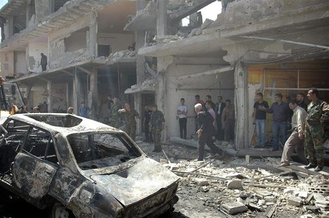 People gather at the site of two car bomb attacks at al-Abassia roundabout in Homs April 29, 2014, in this handout released by Syria's natio People gather at the site of two car bomb attacks at al-Abassia roundabout in Homs April 29, 2014, in this handout released by Syria's natio
